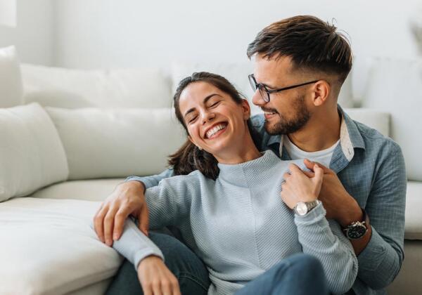Couple smiling in front of lounge suite