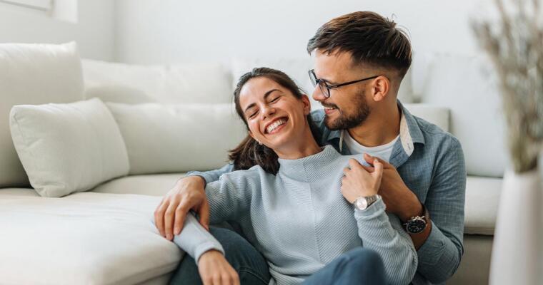 Couple smiling in front of lounge suite